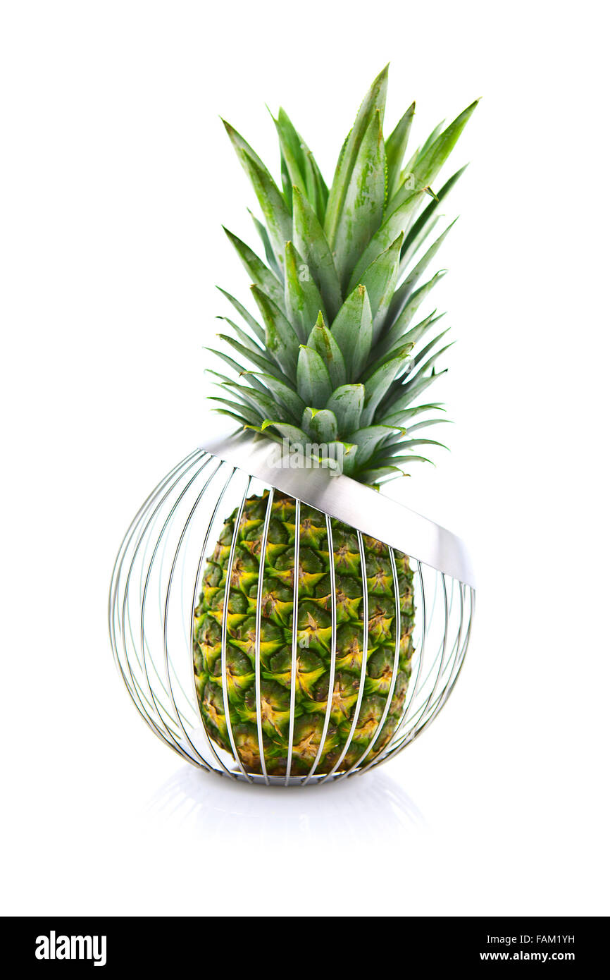 Piña fresca en frutero de alambre aislado en blanco Foto de stock