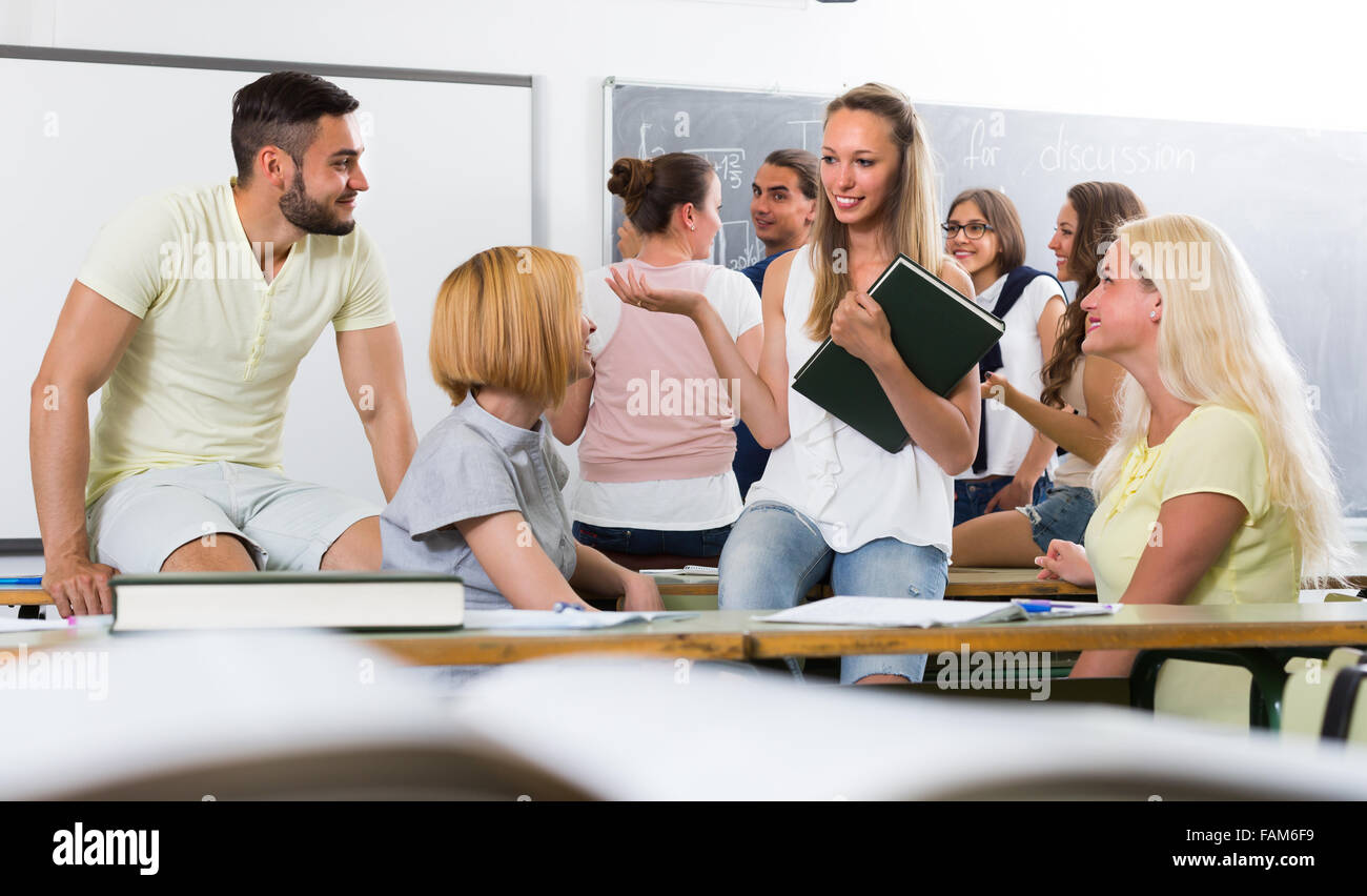 Amable estudiantes adultos 20-30 años conversando mientras está sentado en la habitación Foto de stock