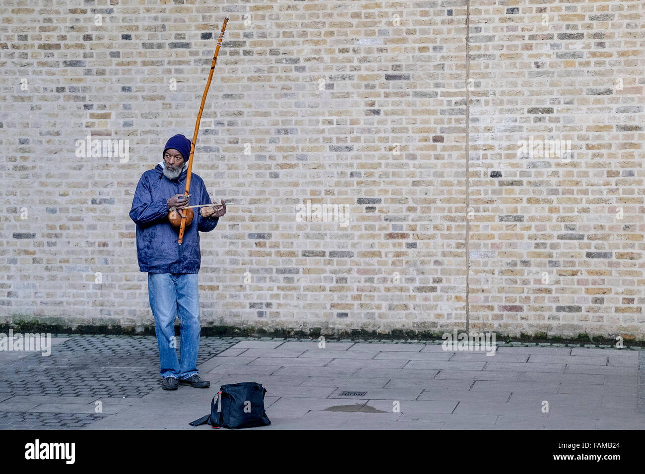 En la orilla sur de Londres, un músico callejero Rabimsha juega un berimbau, un instrumento/brasileña tradicional africana. Foto de stock