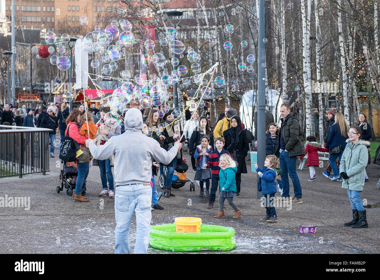 Una calle animador crea burbujas para divertir a los niños y a sus padres en la orilla sur de Londres. Foto de stock
