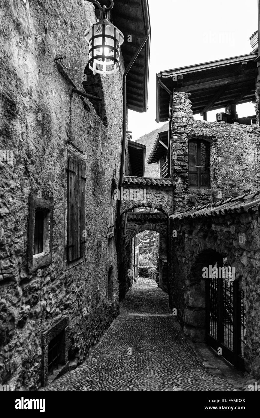 Estrecho callejón de un pueblo medieval en el norte de Italia. Foto de stock