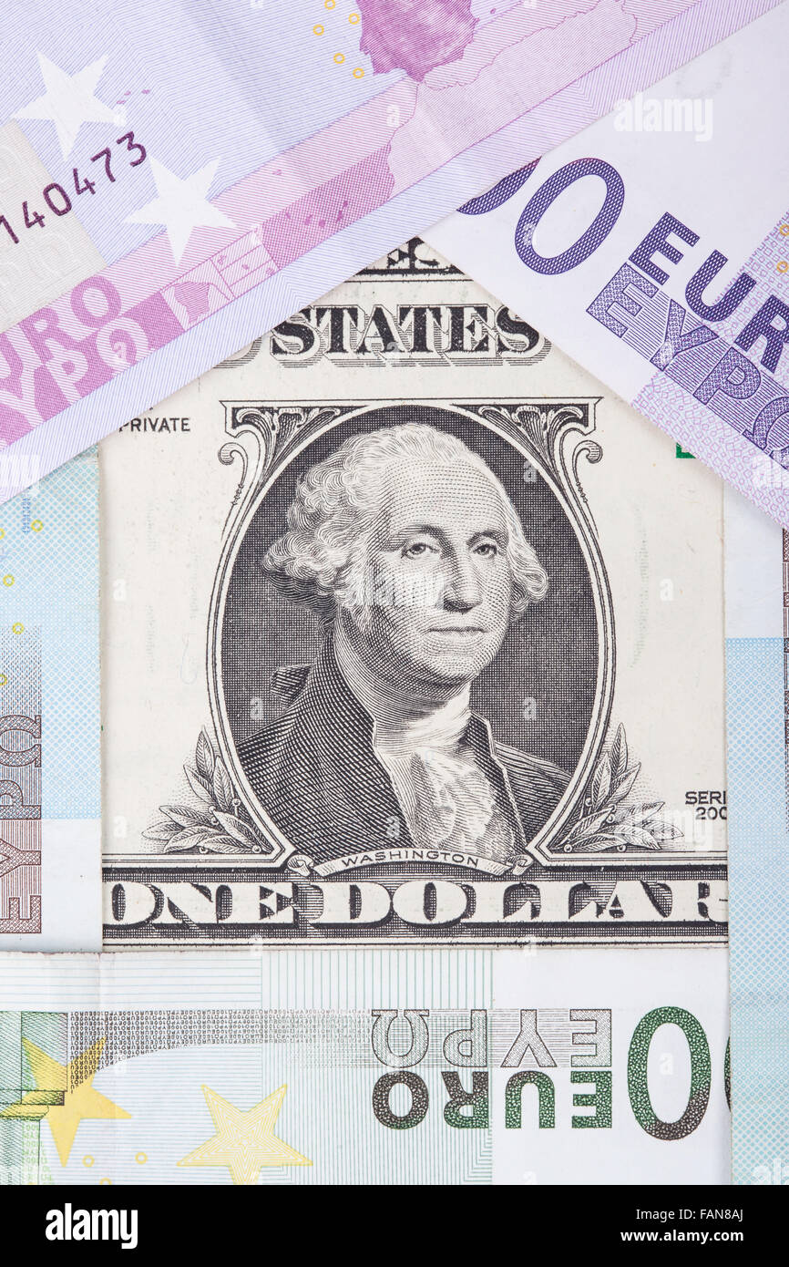 Los billetes euro y dólar en forma de casa Foto de stock