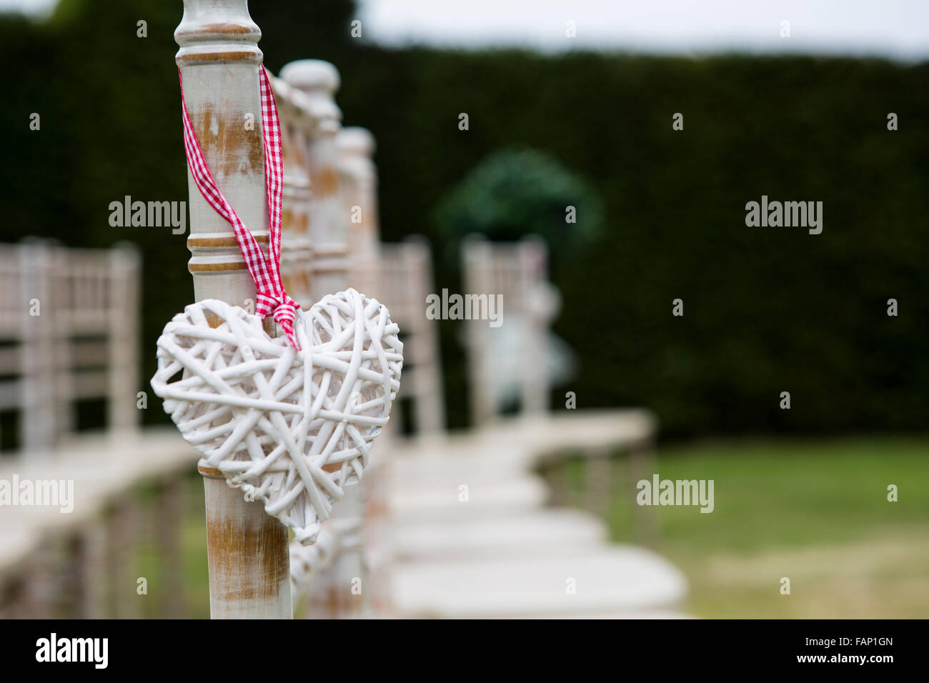 Día de boda decoración de mimbre en forma de corazón colgado en una silla  en la ceremonia al aire libre en Inglaterra Fotografía de stock - Alamy