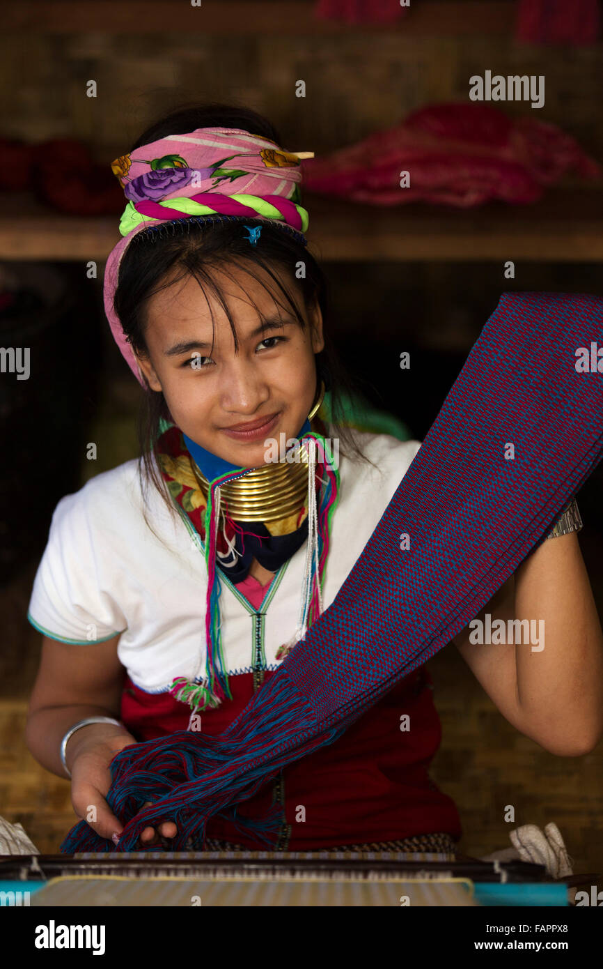 Una mujer de la tribu Kayan tejiendo en un taller en el Lago Inle en Myanmar (Birmania). La mujer viste bobinas de latón en su cuello. Foto de stock