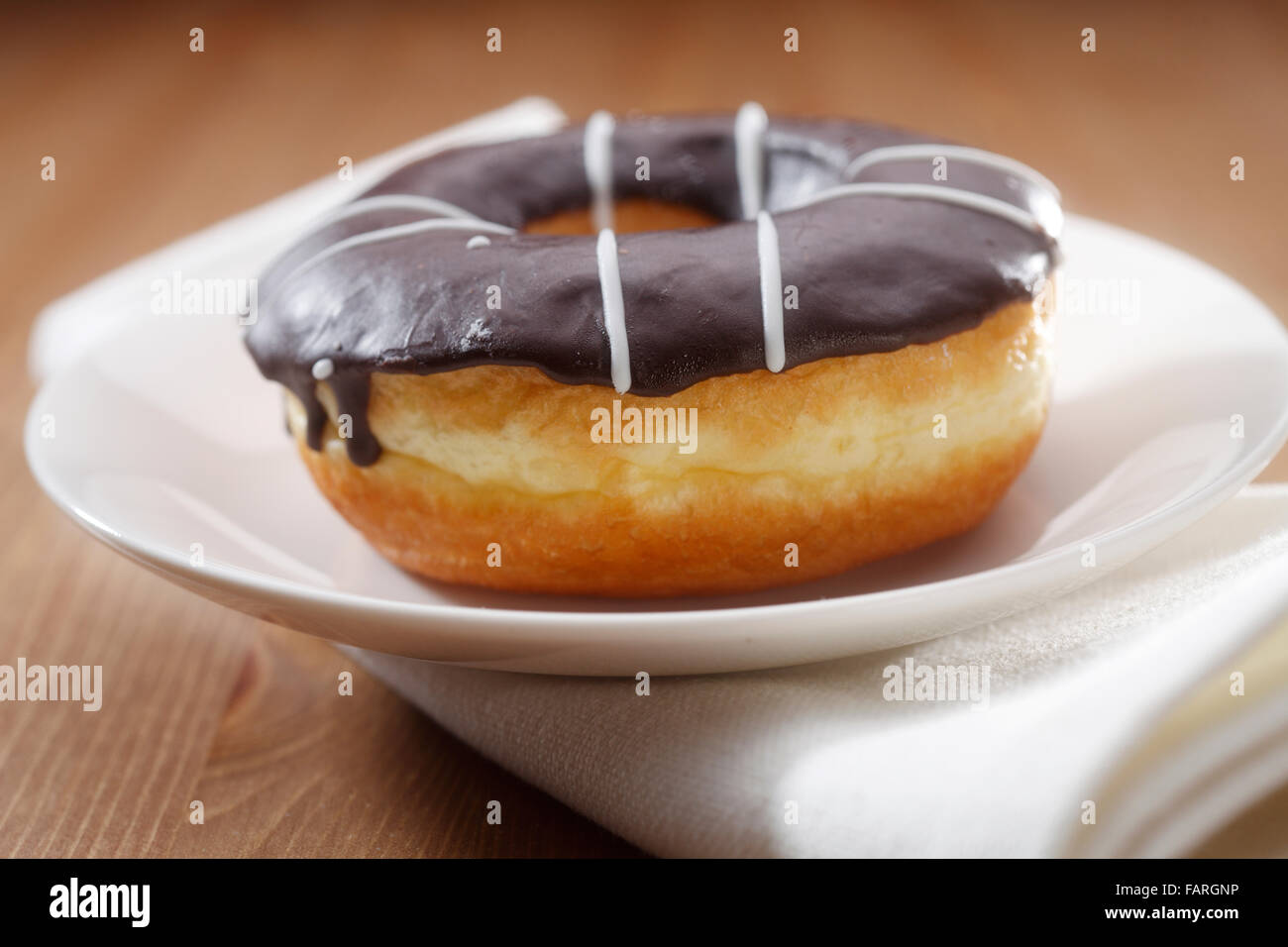 Cerca de filmación Chocolate-Glazed donut en una placa Foto de stock
