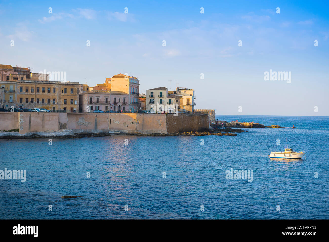 Siracusa Sicilia puerto puerto, vista al atardecer de una pequeña embarcación de ocio en el lado oriental de la isla de Ortigia, Siracusa, Sicilia. Foto de stock
