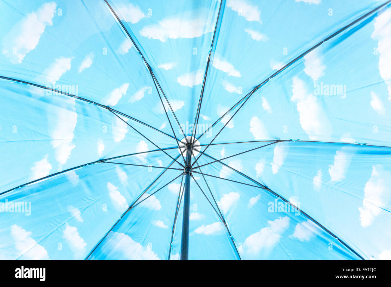 En el interior de un paraguas con nubes blancas en el cielo azul. Una referencia a Magritte o el optimismo y el pensamiento positivo. Foto de stock