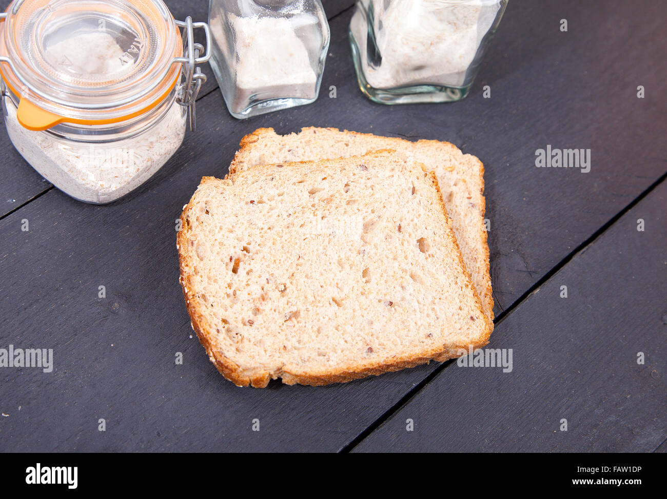 Pan sin gluten con flor negra sobre fondo de madera Foto de stock
