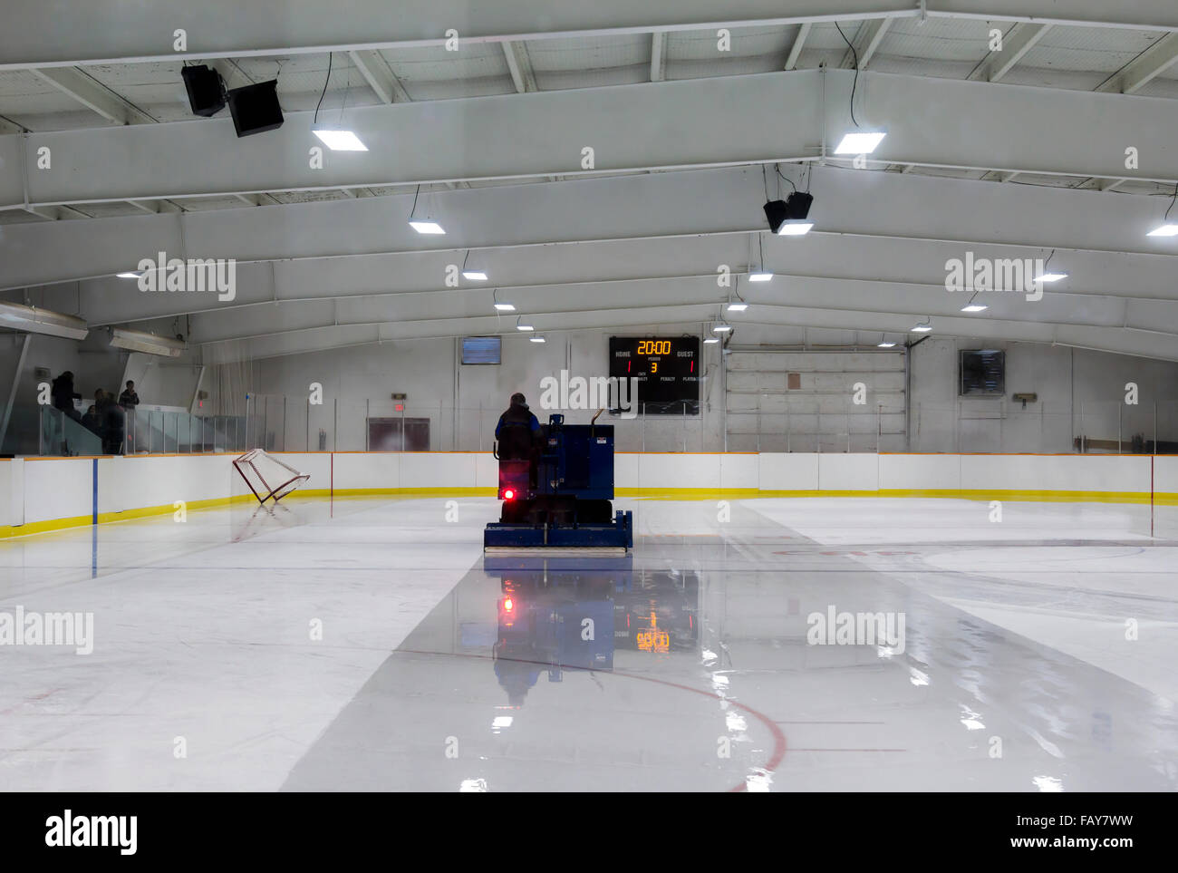 El zamboni conductor se derrite el hielo en una pista de patinaje sobre