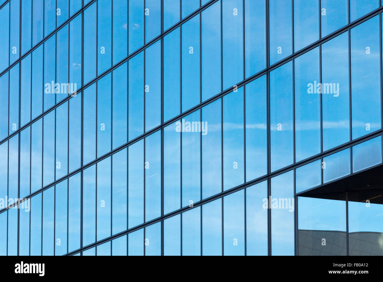 Cielo azul reflejado en la fachada de vidrio de Matrix House en Basing View en Basingstoke, Hampshire, Reino Unido Foto de stock