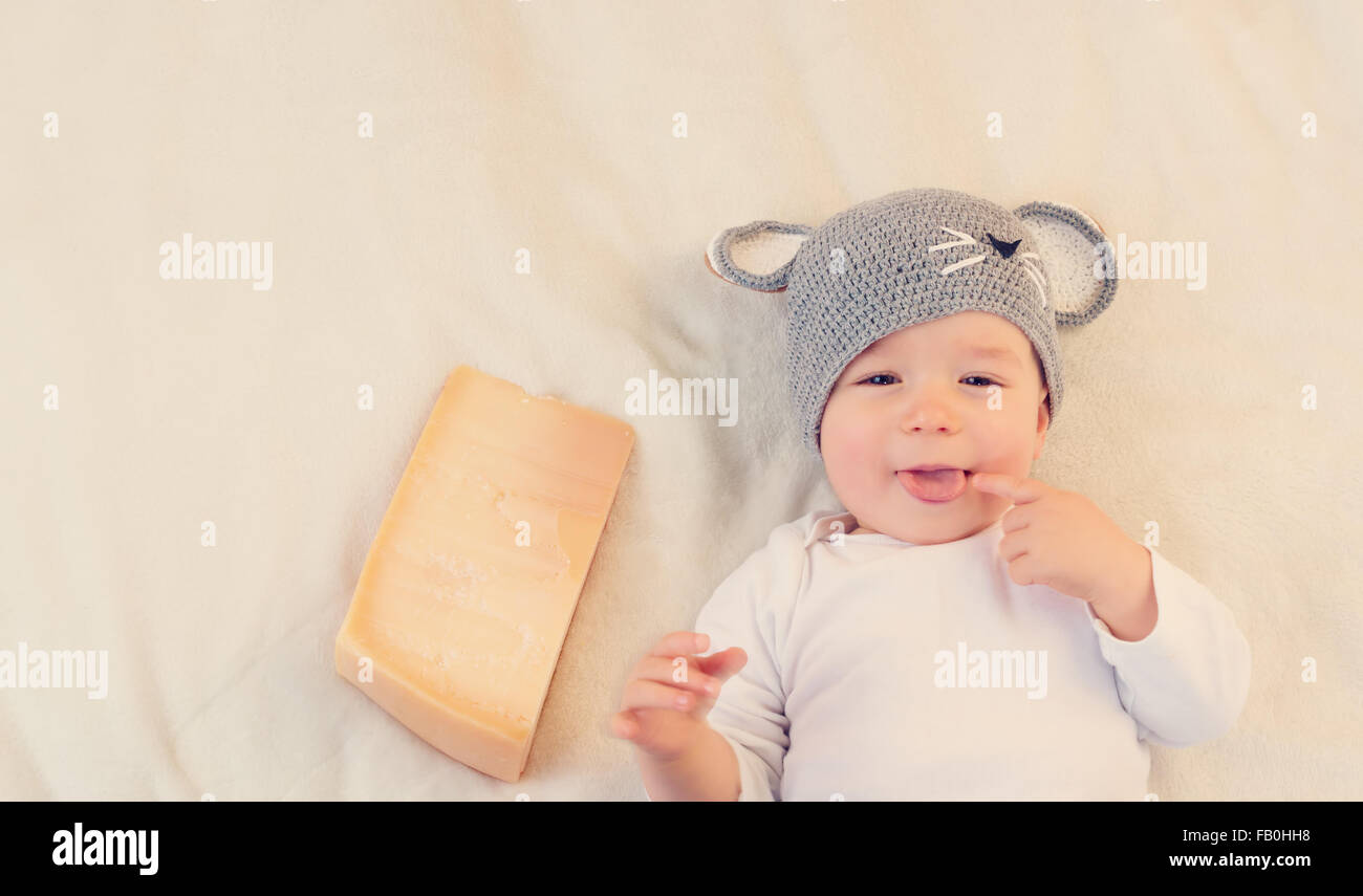 Baby Boy en ratón hat acostado sobre una manta con queso Foto de stock