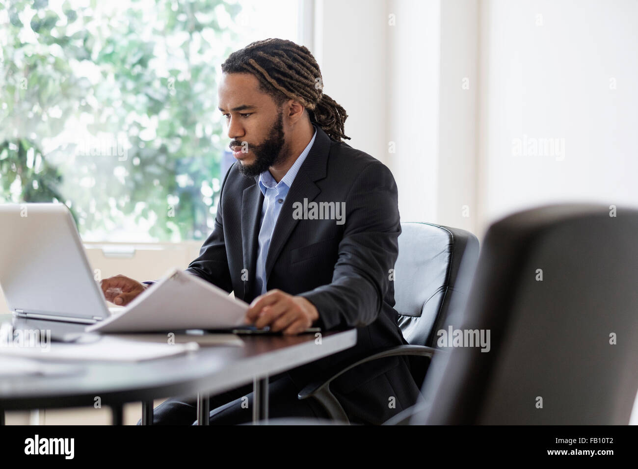 Empresario concentrada trabajando con un portátil en una mesa en la oficina Foto de stock