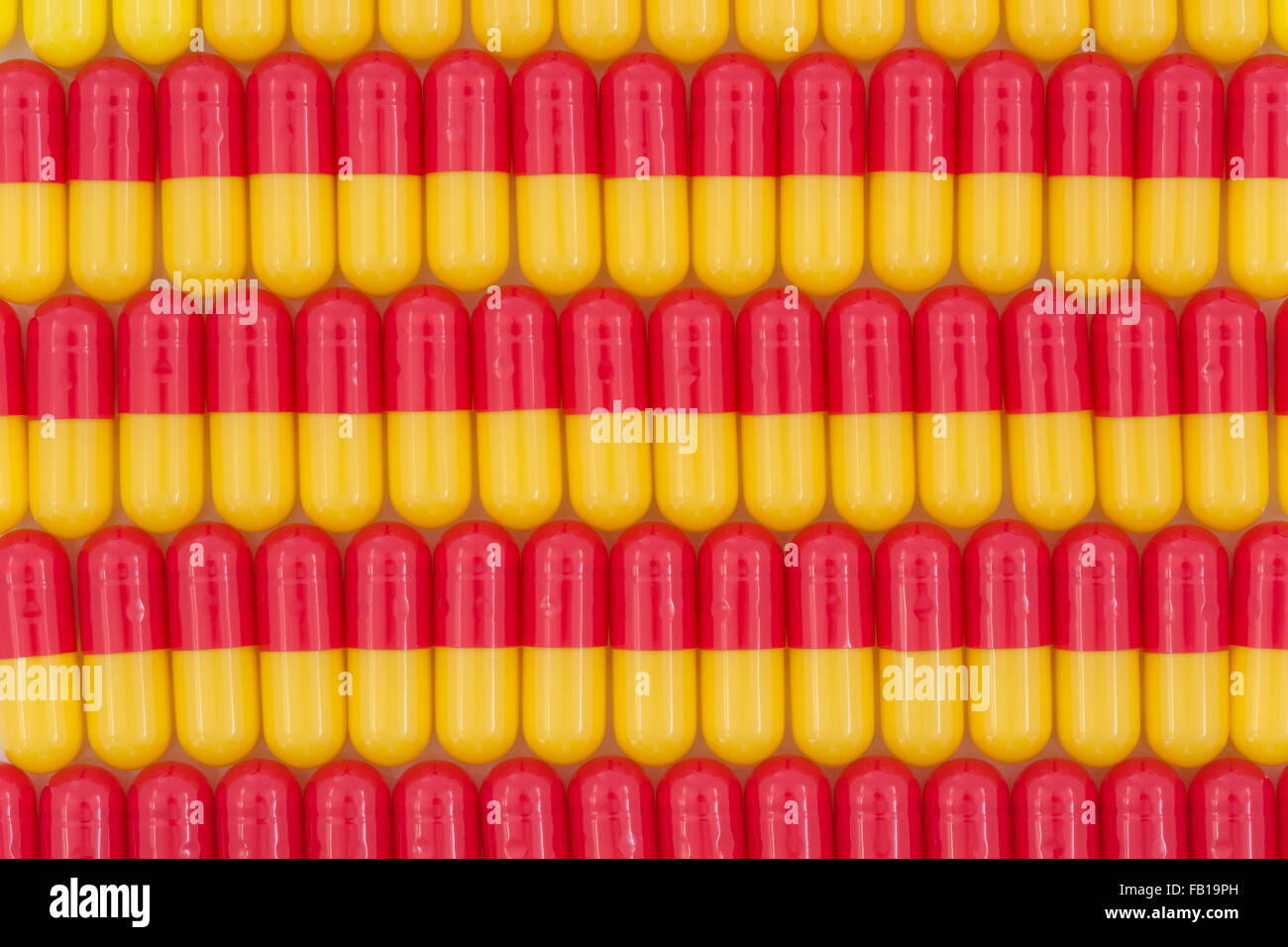 Primer plano de pastillas - forma de cápsula hecha de gelatina. Pastillas rojas / amarillas, metáfora de tomar en las compañías estadounidenses de drogas sobre los altos precios de las drogas, pruebas de drogas. Foto de stock