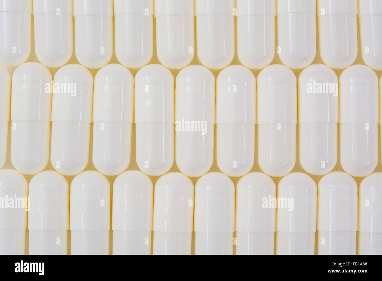 Primer plano de pastillas blancas - forma de cápsula hecha de gelatina. Pastillas blancas. Big Pharma metáfora, concepto de ensayos de drogas. Foto de stock
