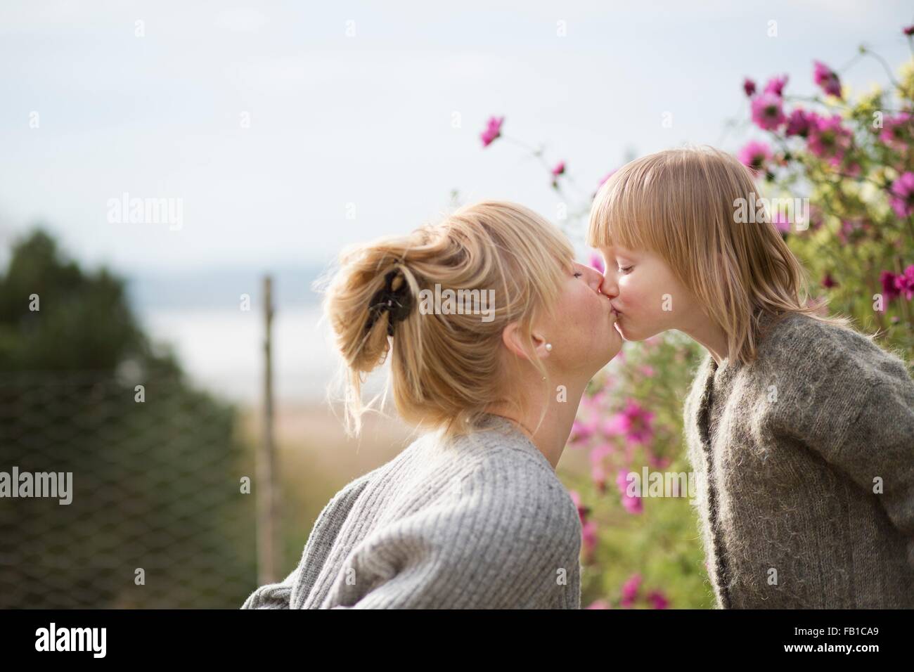 Besos madre hijo en el jardín orgánico Foto de stock