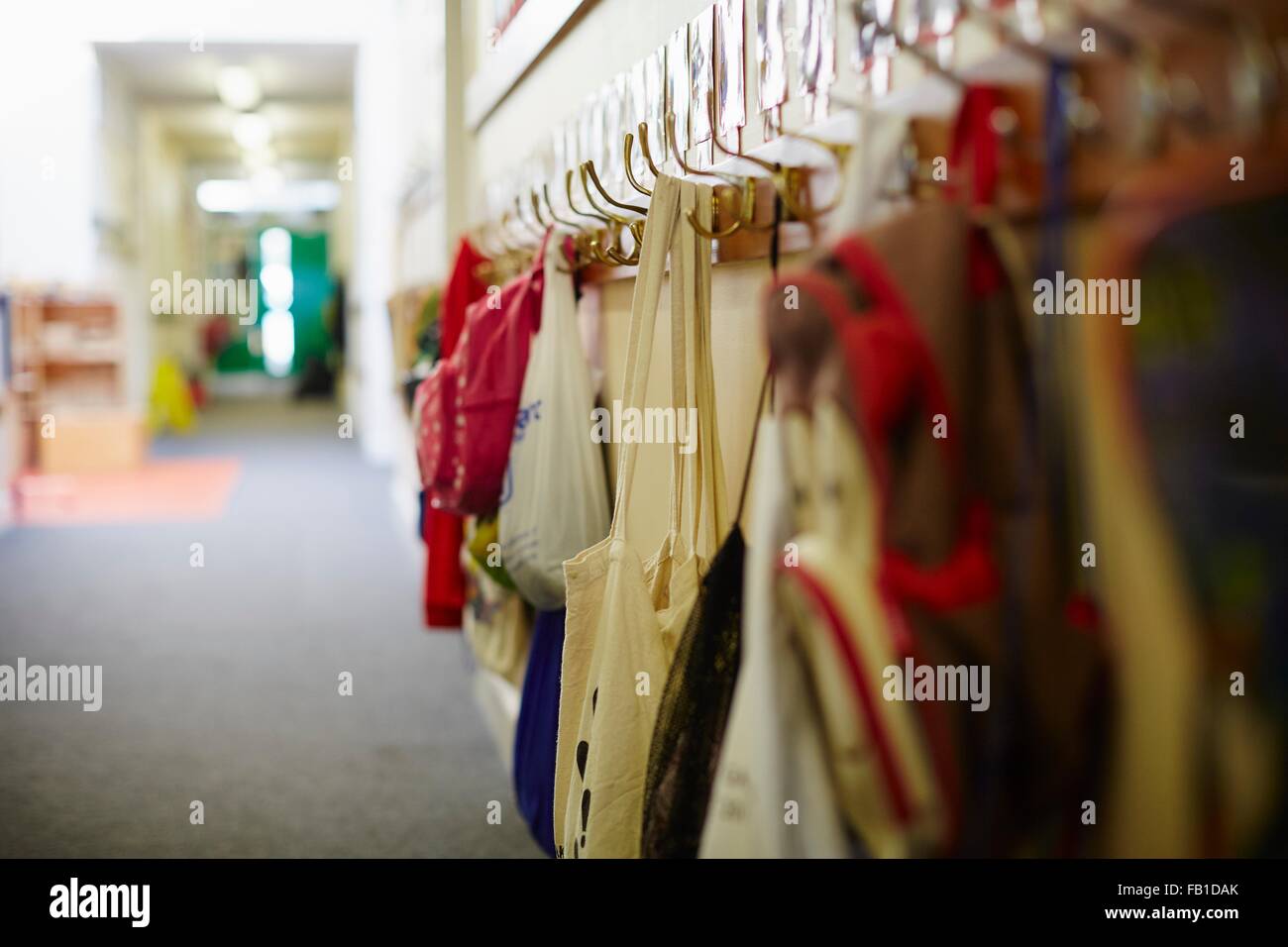 Mochilas escolares colgando en la fila de ganchos para colgar la ropa en la  escuela elemental Fotografía de stock - Alamy