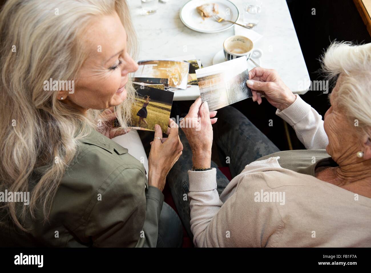 Madre E Hija Sentados Juntos En La Cafetería Mirando Fotos Vista Trasera Fotografía De Stock 