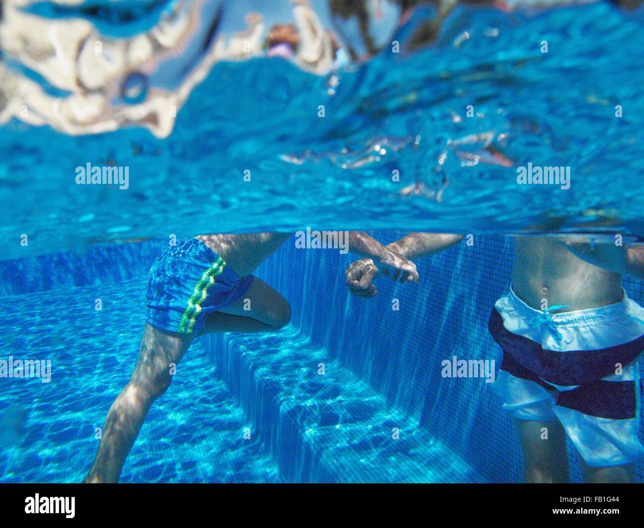 Vista submarina de muchachos jugando en la piscina Foto de stock