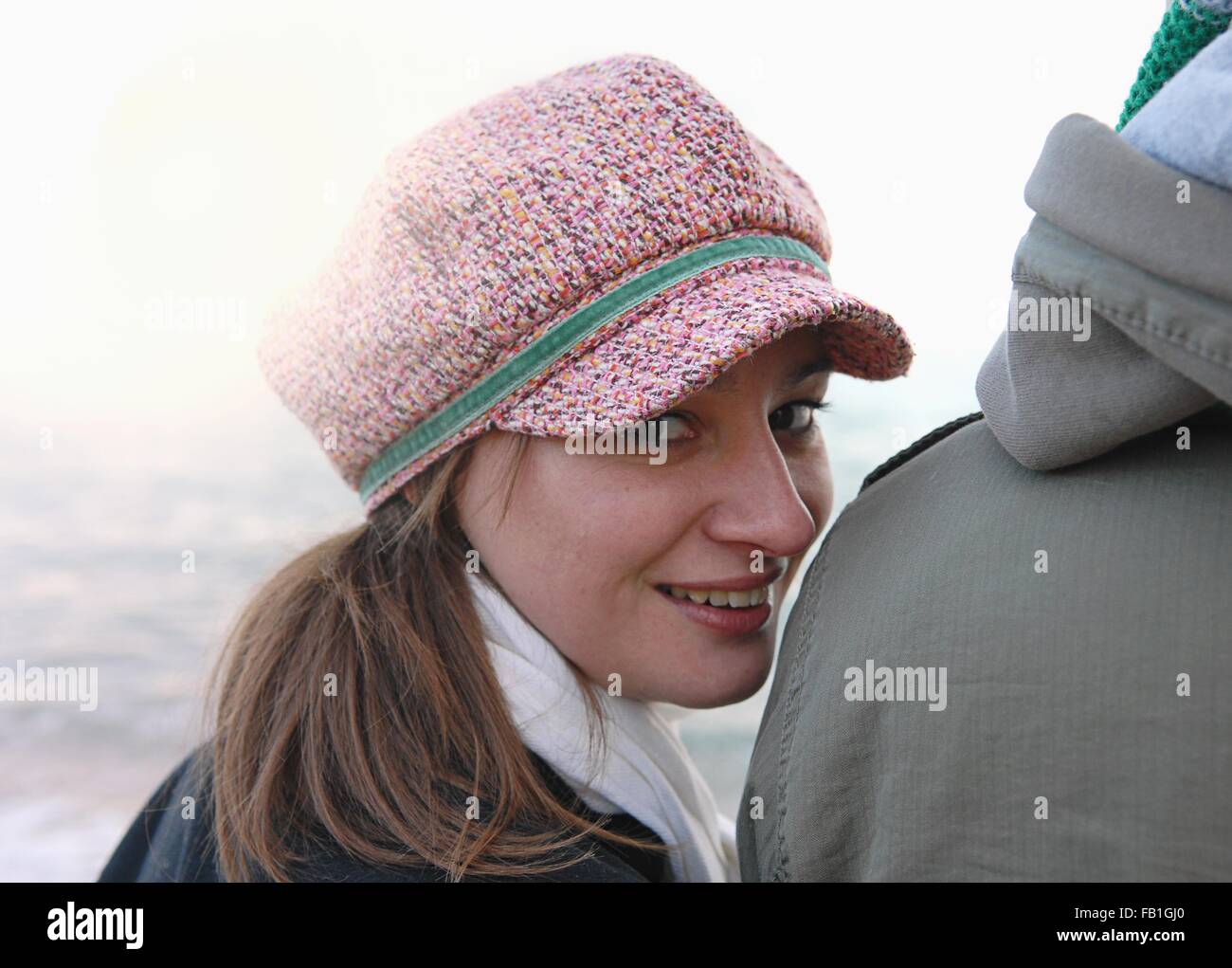 Retrato de mujer joven mirando por encima del hombro en costa novios Foto de stock