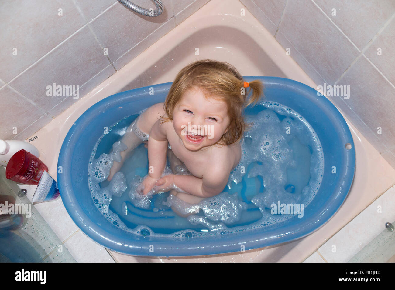 buscar Asco Pelmel Uno / 1 año de edad - casi un niño - disfruta de un baño en una bañera  portátil colocado en un hotel / casa de huéspedes del plato de ducha  Fotografía de stock - Alamy