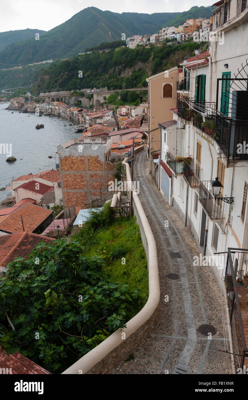 Calles estrechas y escaleras junto a lindas casas italianas en la vieja ciudad de Scilla frente al océano Foto de stock