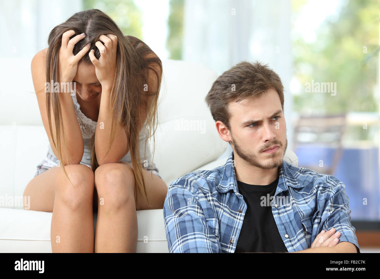 Mala relación con una pareja o matrimonio enojado y triste después argumento sentados en un sofá en casa Foto de stock