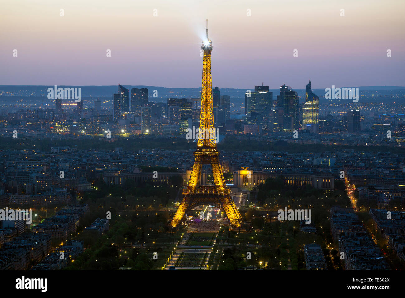 Elevado el horizonte de la ciudad de París iluminada de noche con la torre Eiffel y el barrio La Defense, Francia, Europa Foto de stock