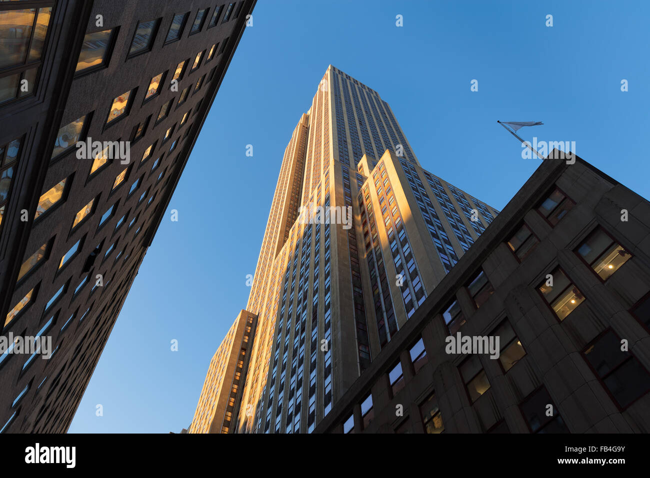 Edificio Empire State al atardecer desde abajo. Un ángulo bajo la vista de los rascacielos de estilo Art Deco situado en Midtown Manhattan, en Nueva York. Foto de stock