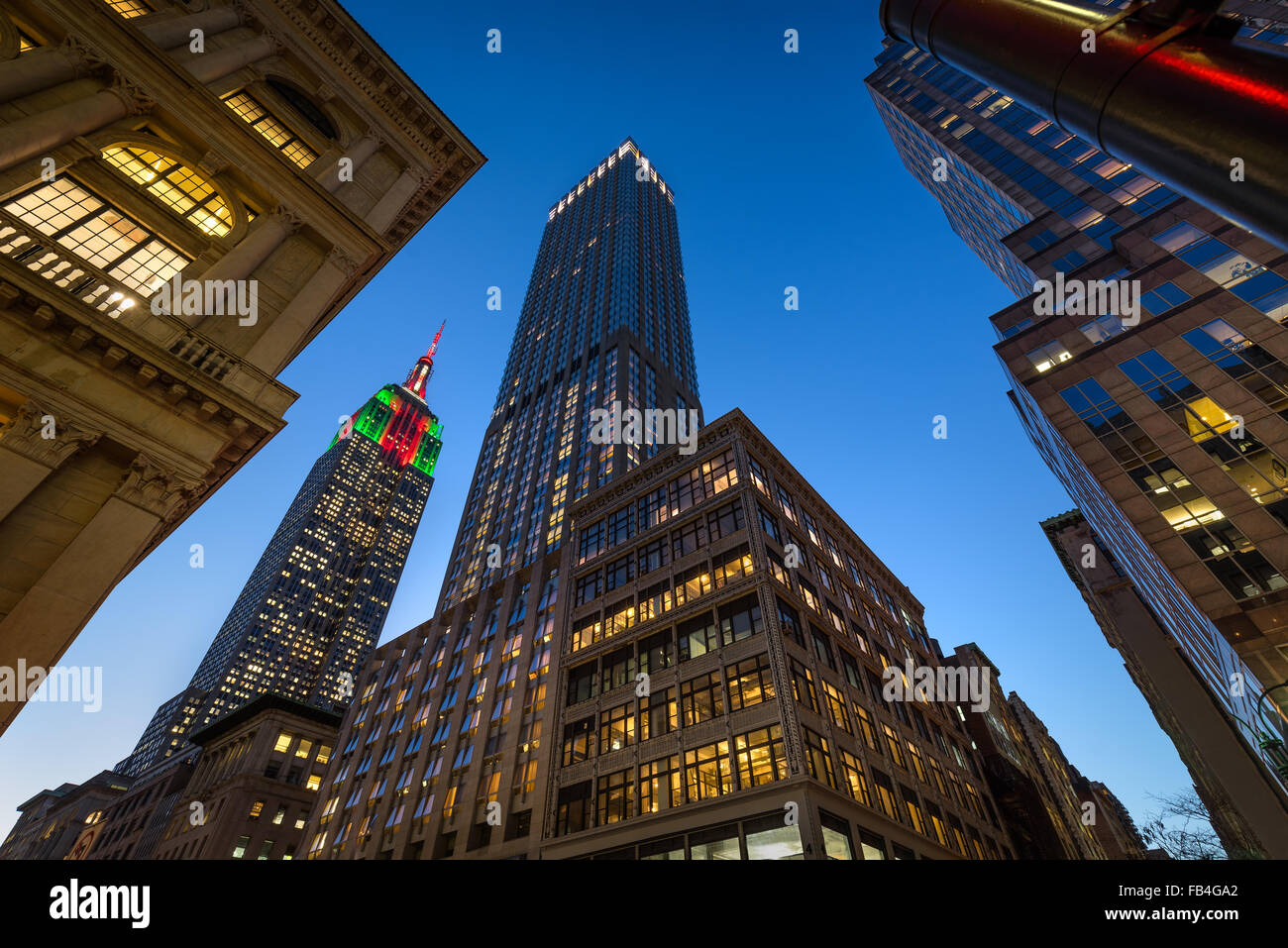El Empire State Building iluminado con luces de Navidad en penumbra. Los rascacielos en 5th Avenue, Midtown Manhattan, en Nueva York. Foto de stock