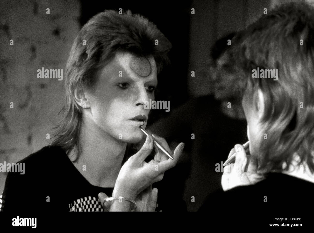 Lewisham, Londres, Inglaterra, Reino Unido. 22 de mayo de 1973. Aplicación de David Bowie Ziggy Stardust maquillaje en vestidor backstage. Su guitarrista Mick Ronson está detrás de él y puede verse reflejado en el espejo. Roger Bamber/Alamy Live News Foto de stock