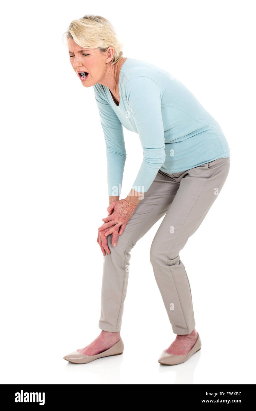 Mujer de mediana edad con dolor de rodilla aislado en blanco Foto de stock