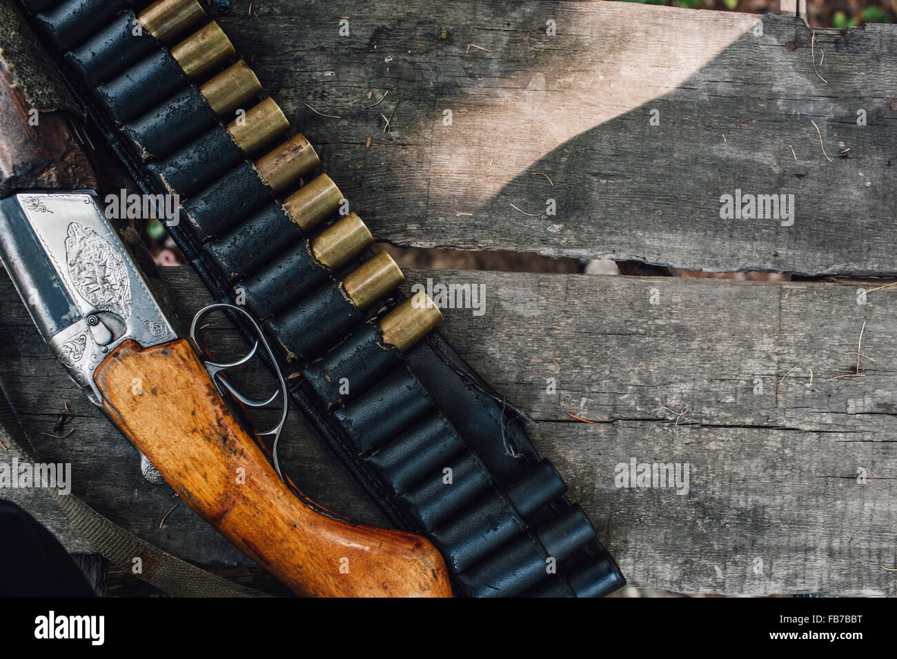 Un alto ángulo de visualización de la pistola y balas en el banco Foto de stock