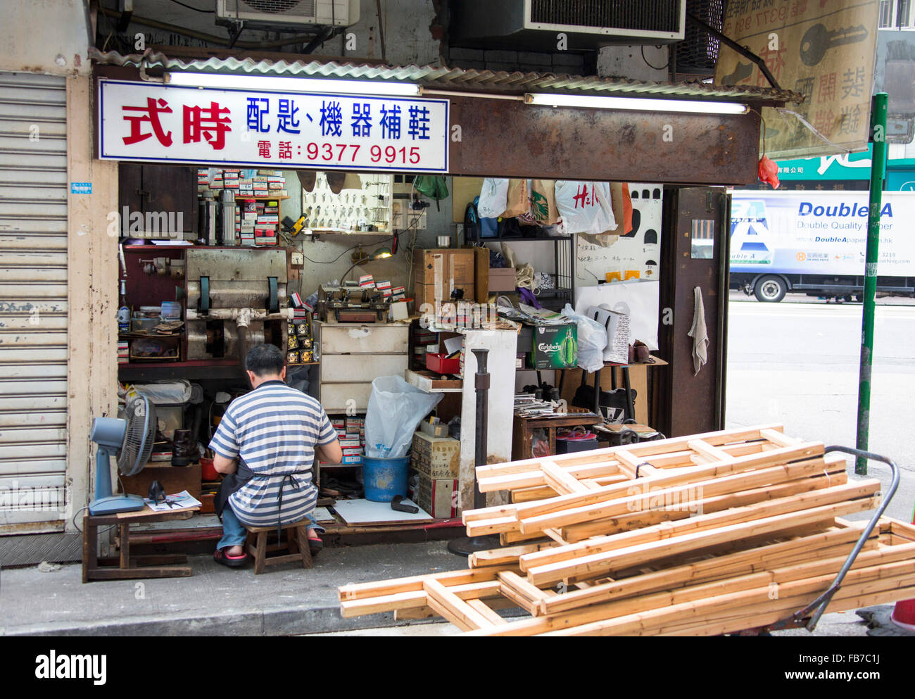 Tienda de reparación de zapatos, zapatero en la calle comercial en Hong Kong, República Popular de China Foto de stock