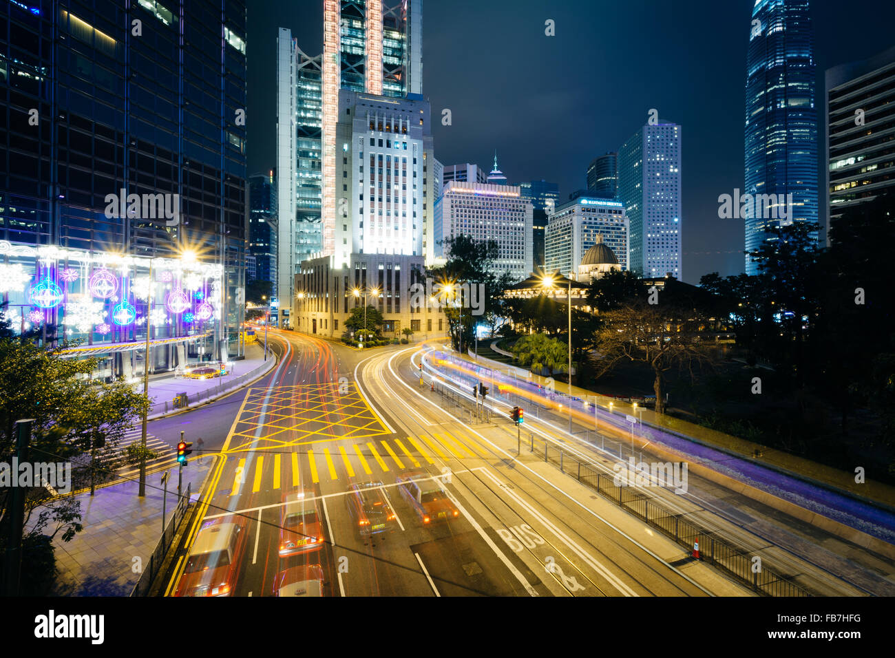 La larga exposición de una intersección y modernos rascacielos en la noche, a nivel central, Hong Kong, Hong Kong. Foto de stock