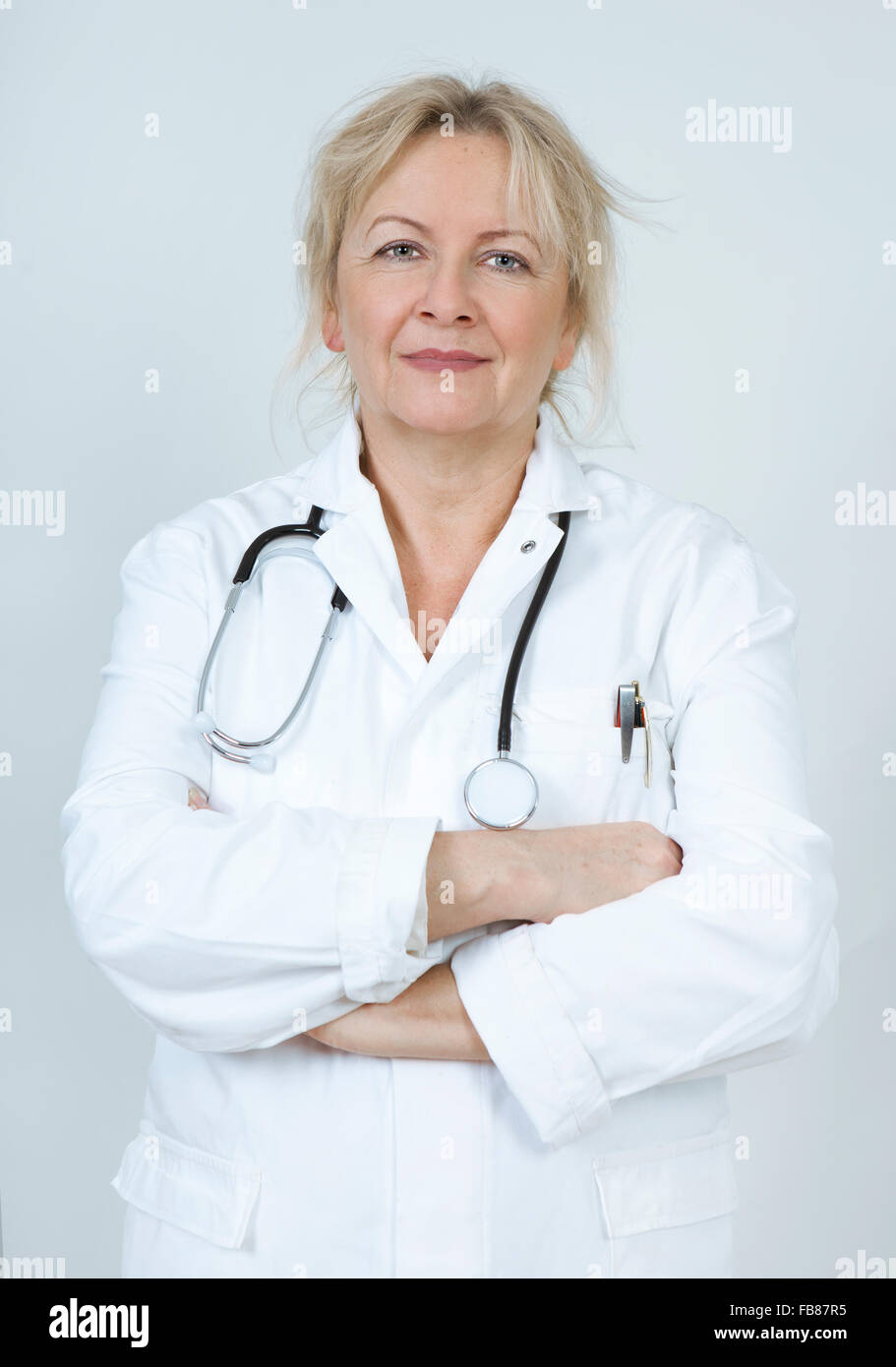 Un médico en una bata blanca con un estetoscopio Foto de stock