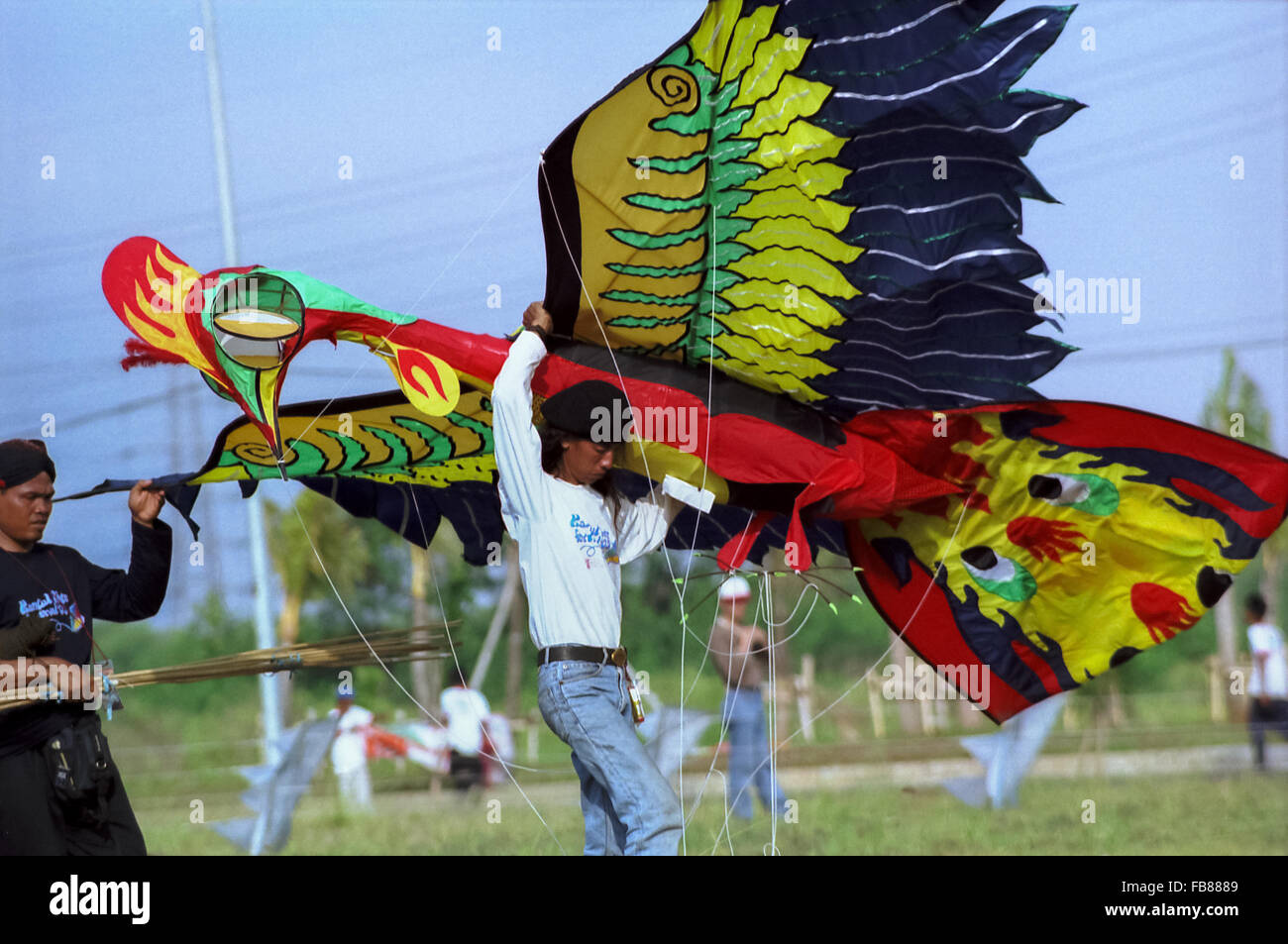 Los hombres llevan un gran cometa en forma de pájaro durante el Festival Internacional de Cometas de Yakarta en Carnaval Playa, Ancol, Yakarta Norte, Julio 09-11, 2004. Foto de stock