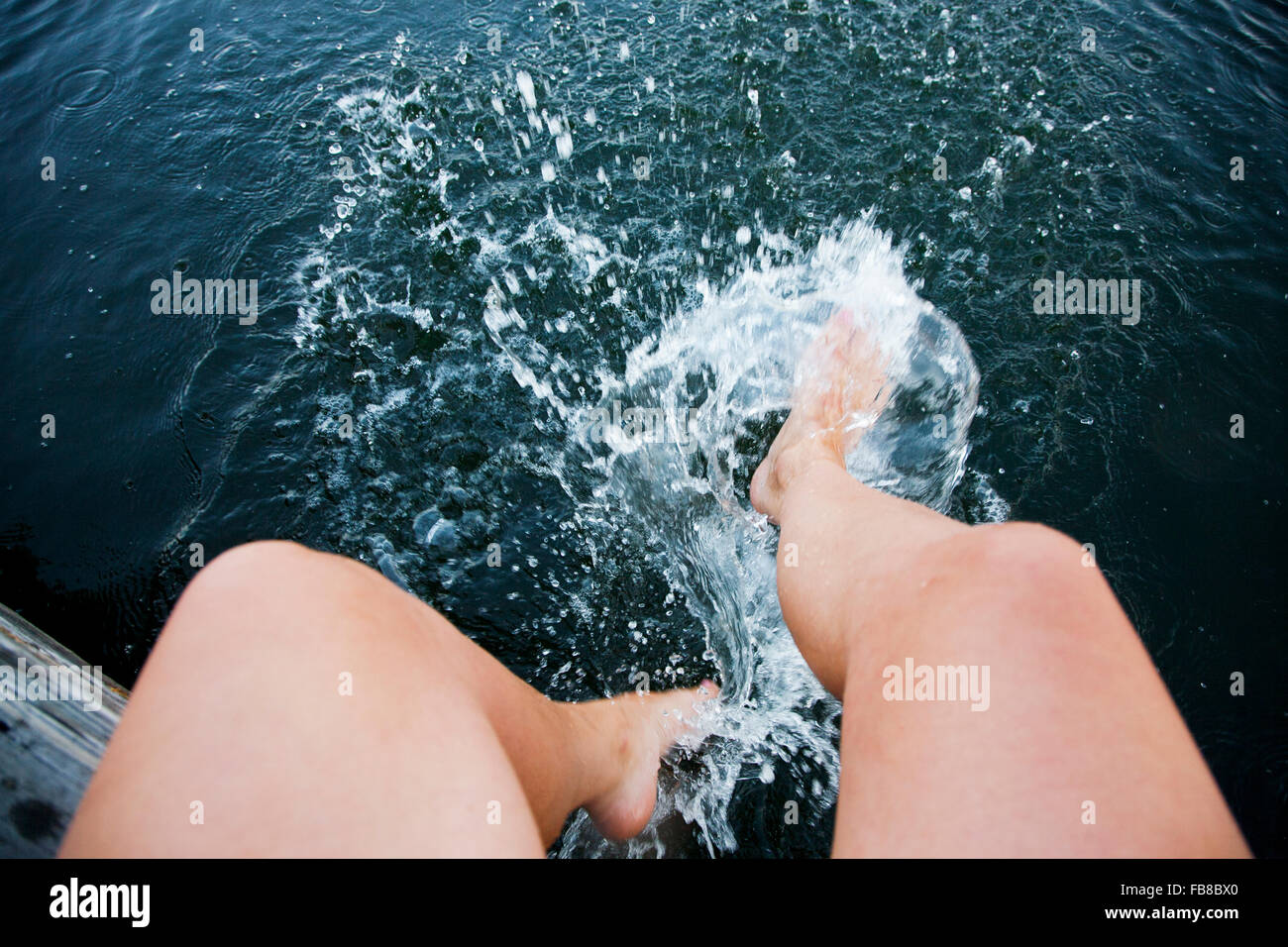 Suecia, Uppland, archipiélago de Estocolmo, Mujer salpicaduras de agua con pies Foto de stock
