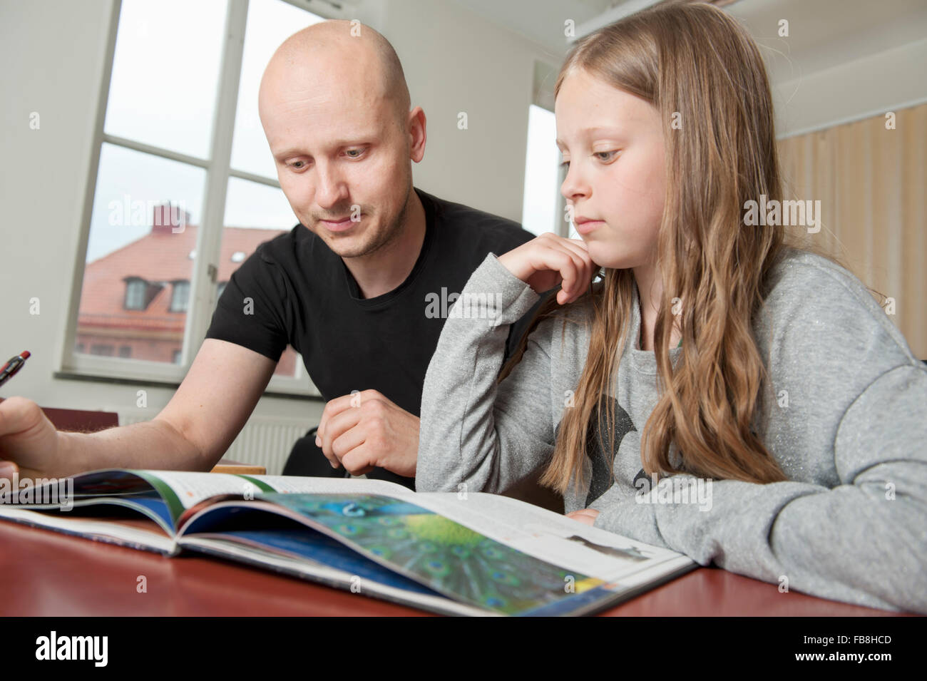 Suecia, profesor explicando libro al estudiante (8-9) Foto de stock