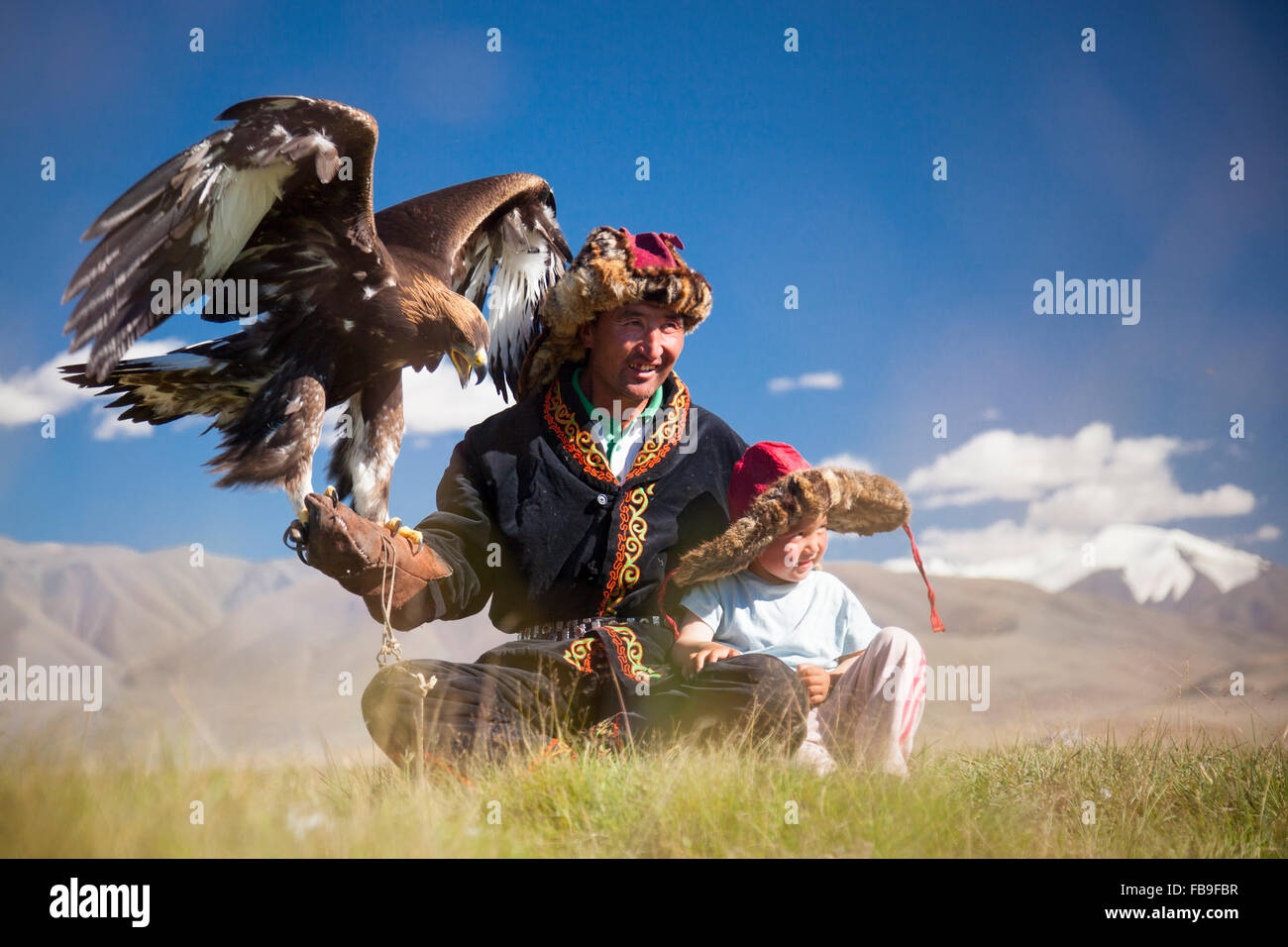 Un águila kazajo hunter y a su hijo en el valle Tsaast Uul, lejano oeste de Mongolia. Foto de stock