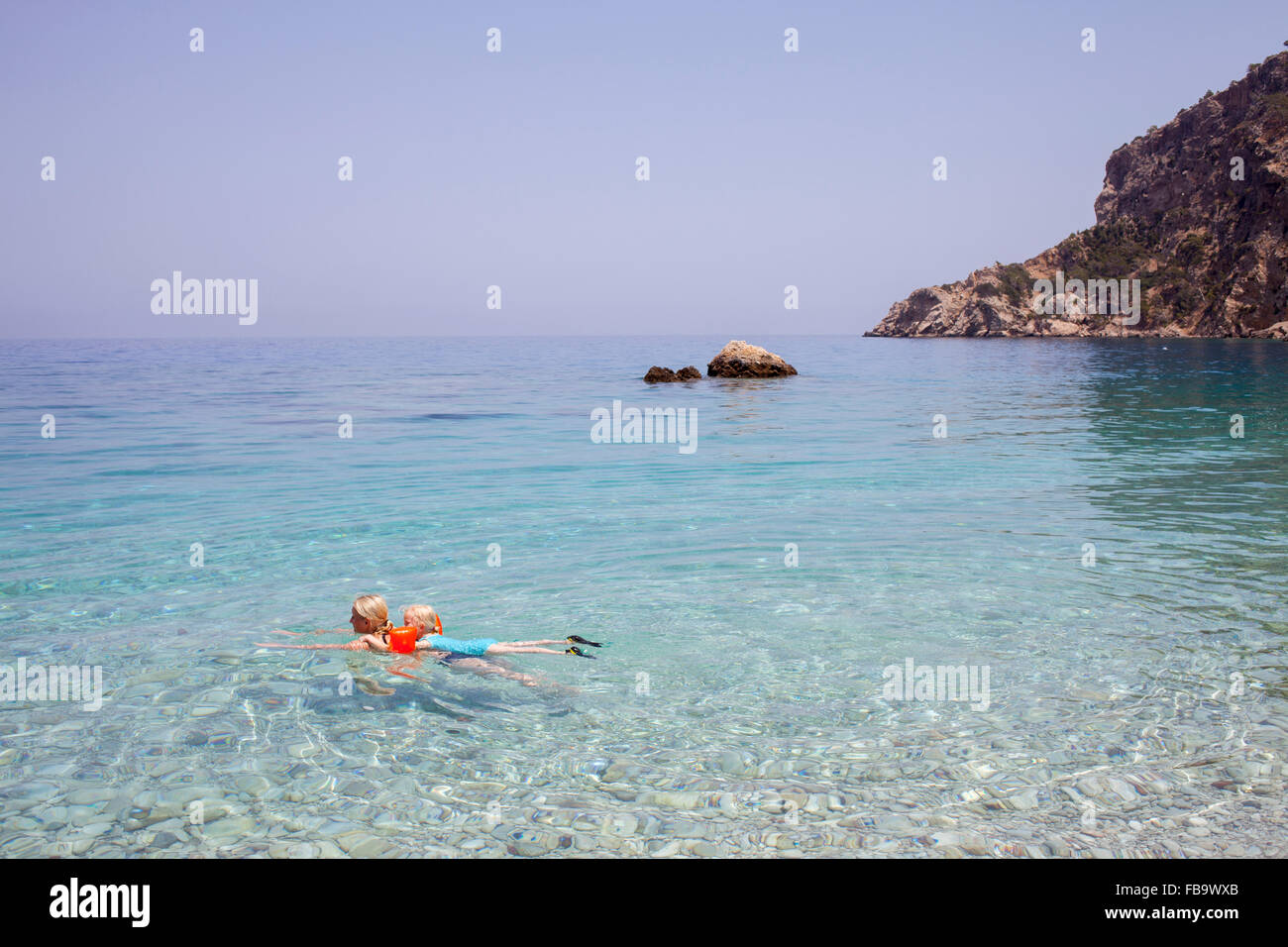 Grecia, Karpathos, la AMOPI, la mujer y la niña (6-7) nadando en el mar Foto de stock