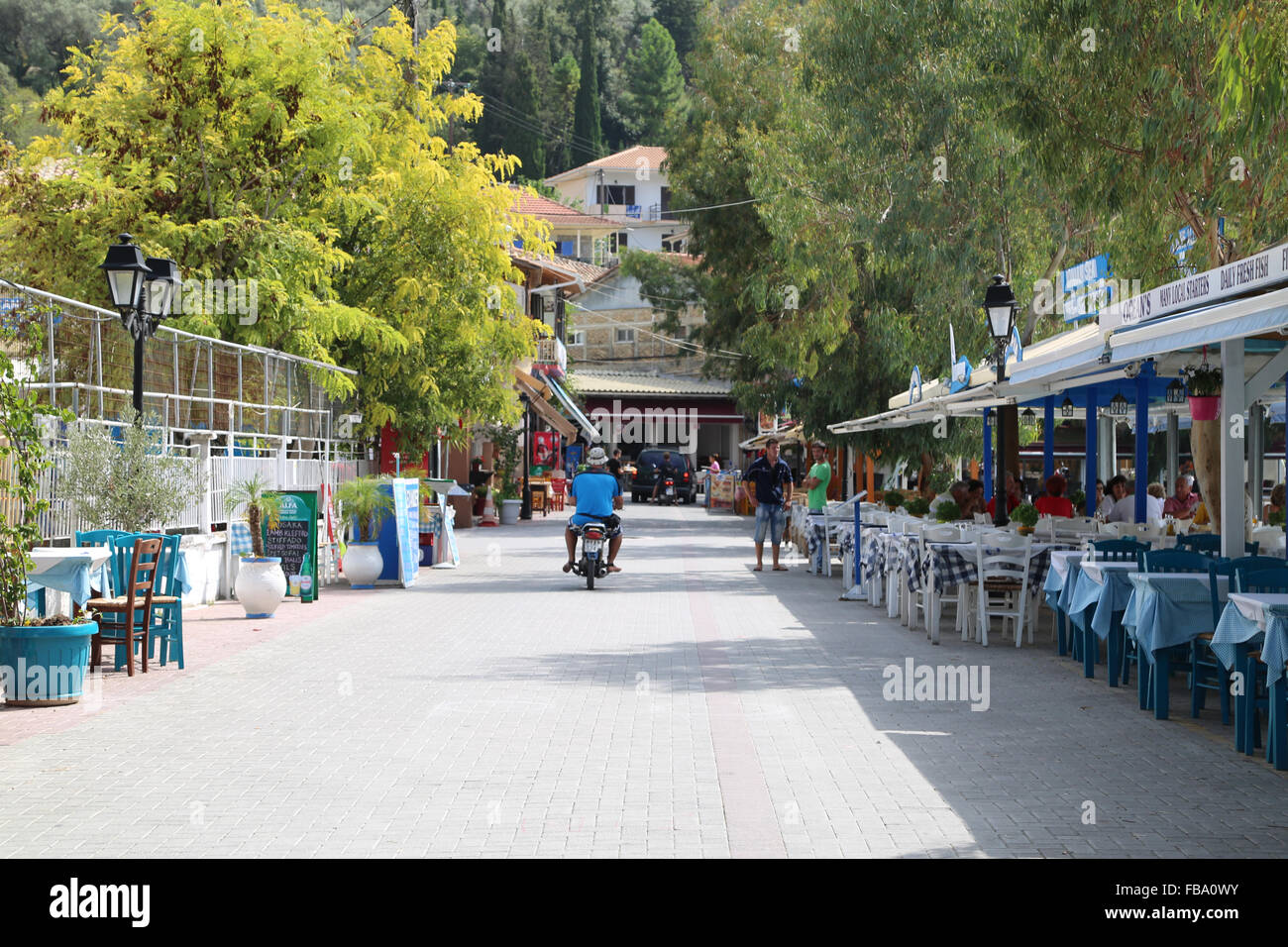 Un ciclomotor lone rider en una taberna Griega, revestidos en carretera Vasiliki, Grecia. Foto de stock