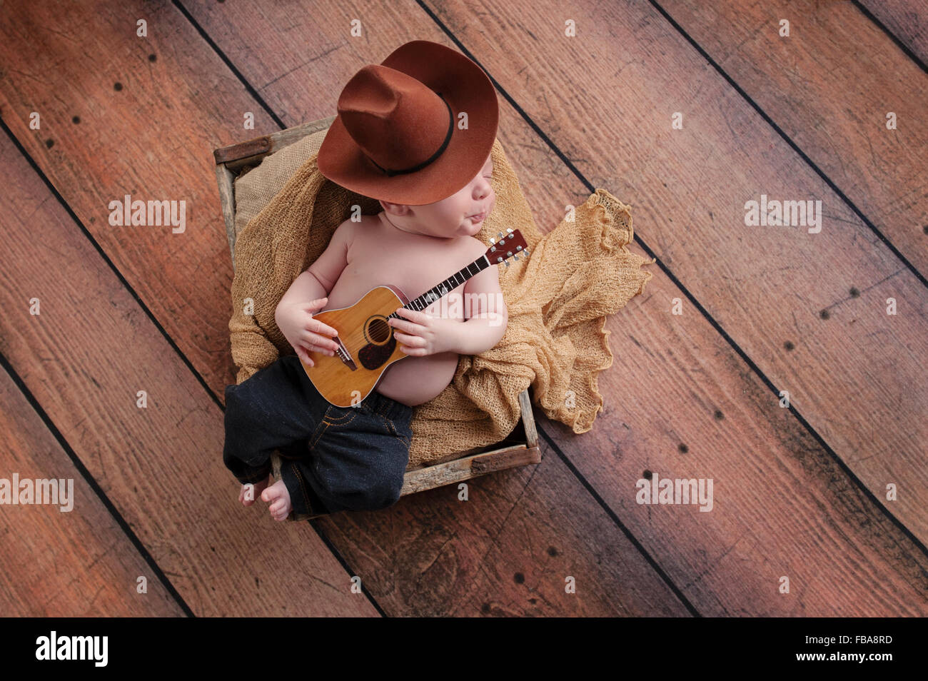 Un bebé de tres semanas de edad vistiendo un de vaquero y jeans y tocando una pequeña Sus labios se guiaba, como si whistlin Fotografía de stock - Alamy