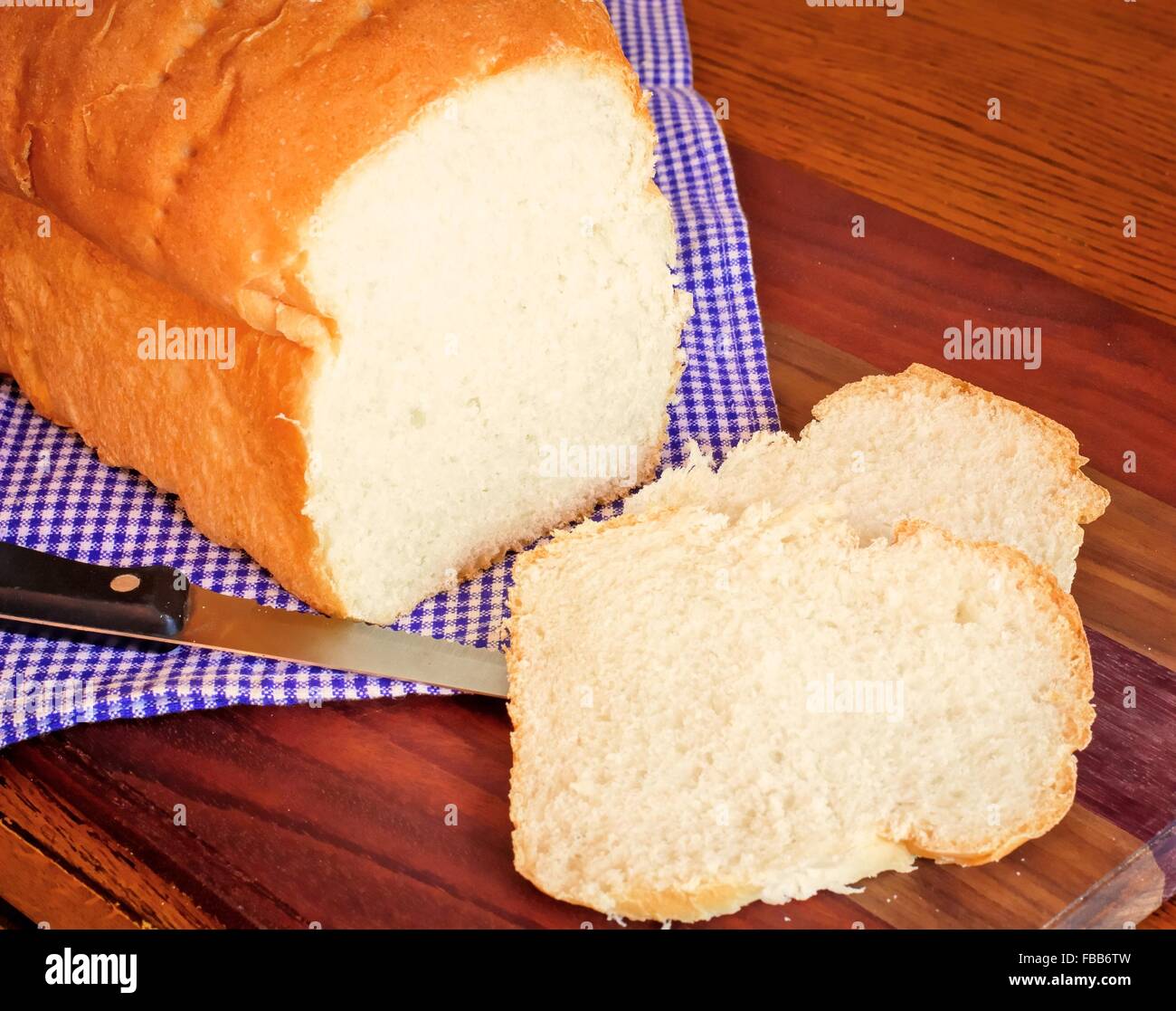 Barra de pan. Recién salido del horno caliente rebanada de pan casero en un fondo rústico. Foto de stock