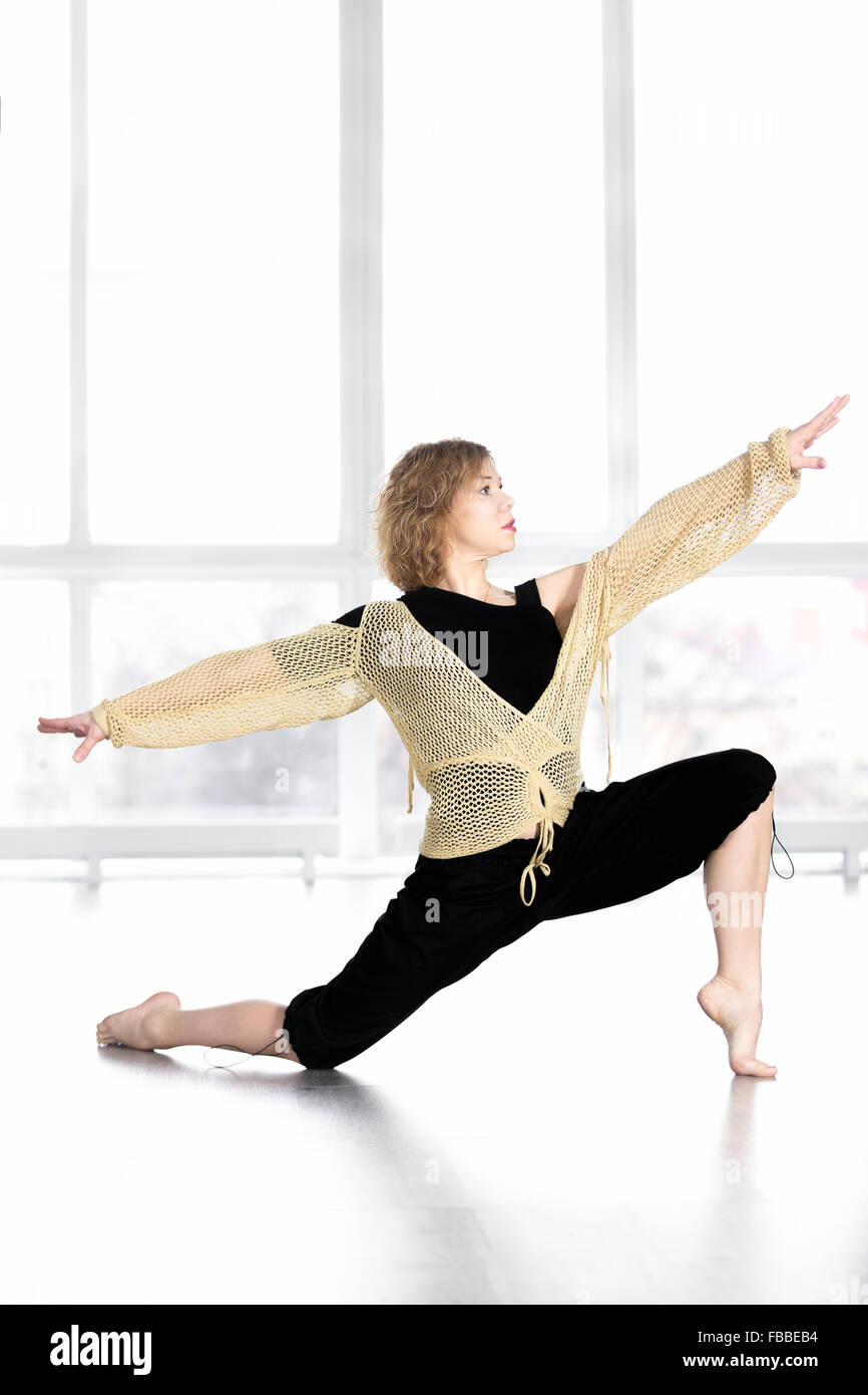 Mujer bailarina deportivo en clase, bailar, hacer ejercicios aeróbicos, fitness entrenamiento coreografía zumba, equilibrando en lunge Foto de stock