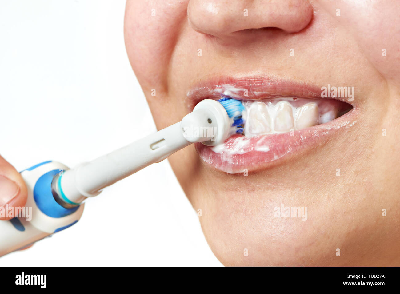 Mujer cepillarse los dientes cepillo dental eléctrico closeup aislado en blanco Foto de stock