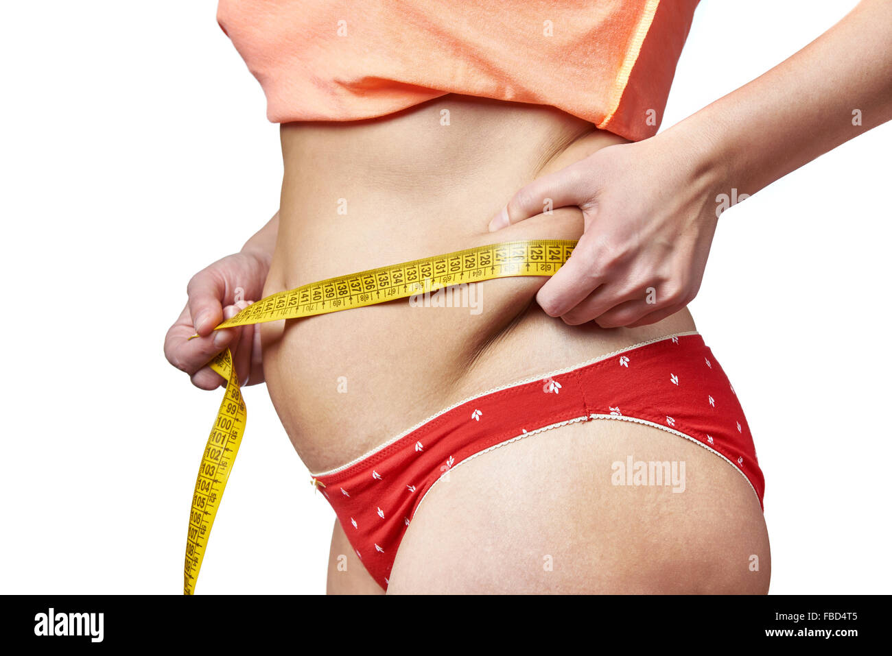 Mujer midiendo la cintura con una cinta métrica y mostrando los depósitos grasos Foto de stock