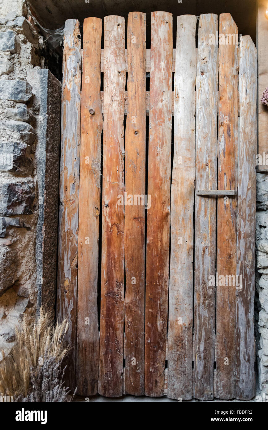 Antigua puerta hecha de tablas de madera áspera juntos verticalmente. Foto de stock