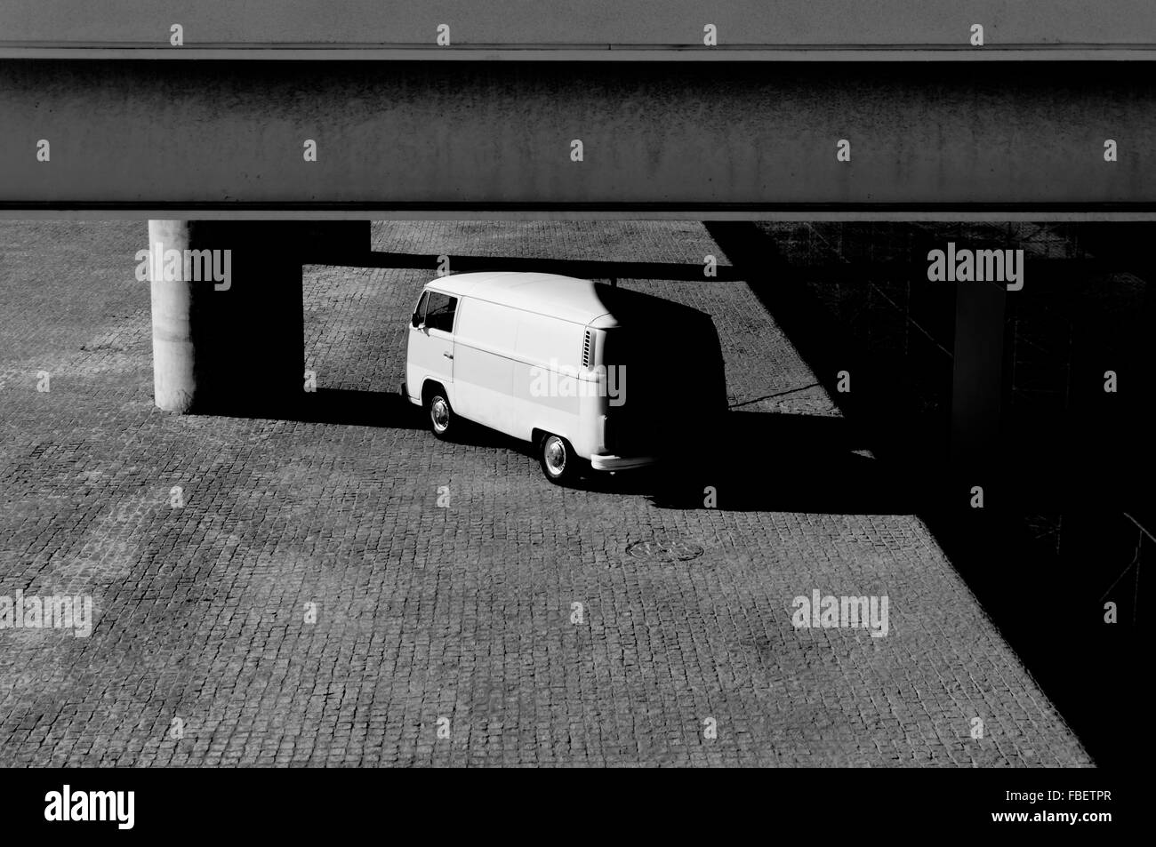 Ángulo de visión baja de Van bajo el edificio en el Estacionamiento Foto de stock