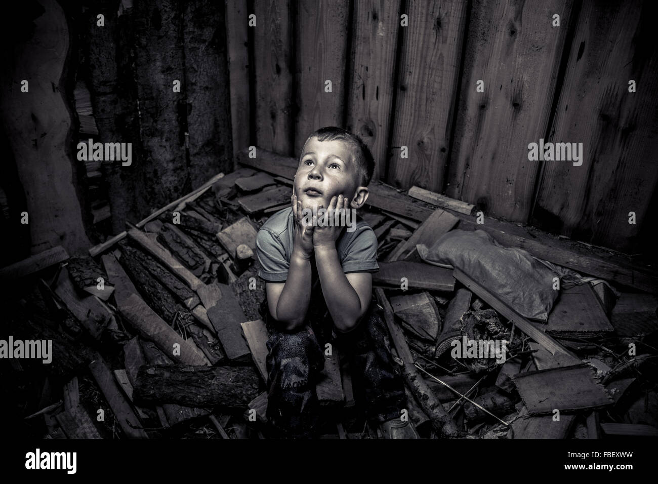 Un alto ángulo de visualización de atrapado muchacho sentado sobre escombros en la habitación Foto de stock