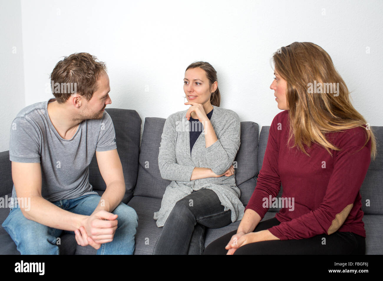 Tres amigos hablando en el salón Foto de stock